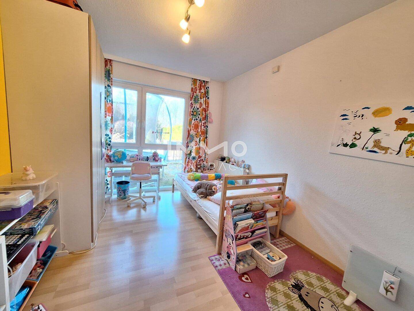 Freundliches Kinderzimmer mit Einzelbett, Schreibtisch und Blick ins Grüne.