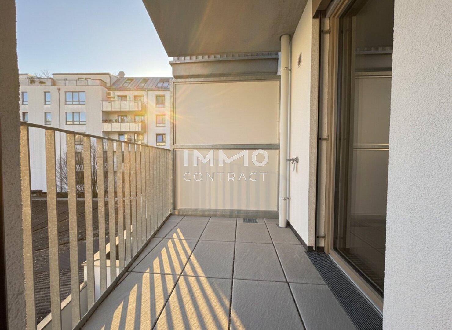Sonniger Balkon mit Fliesenboden und Blick auf die umliegenden Gebäude.