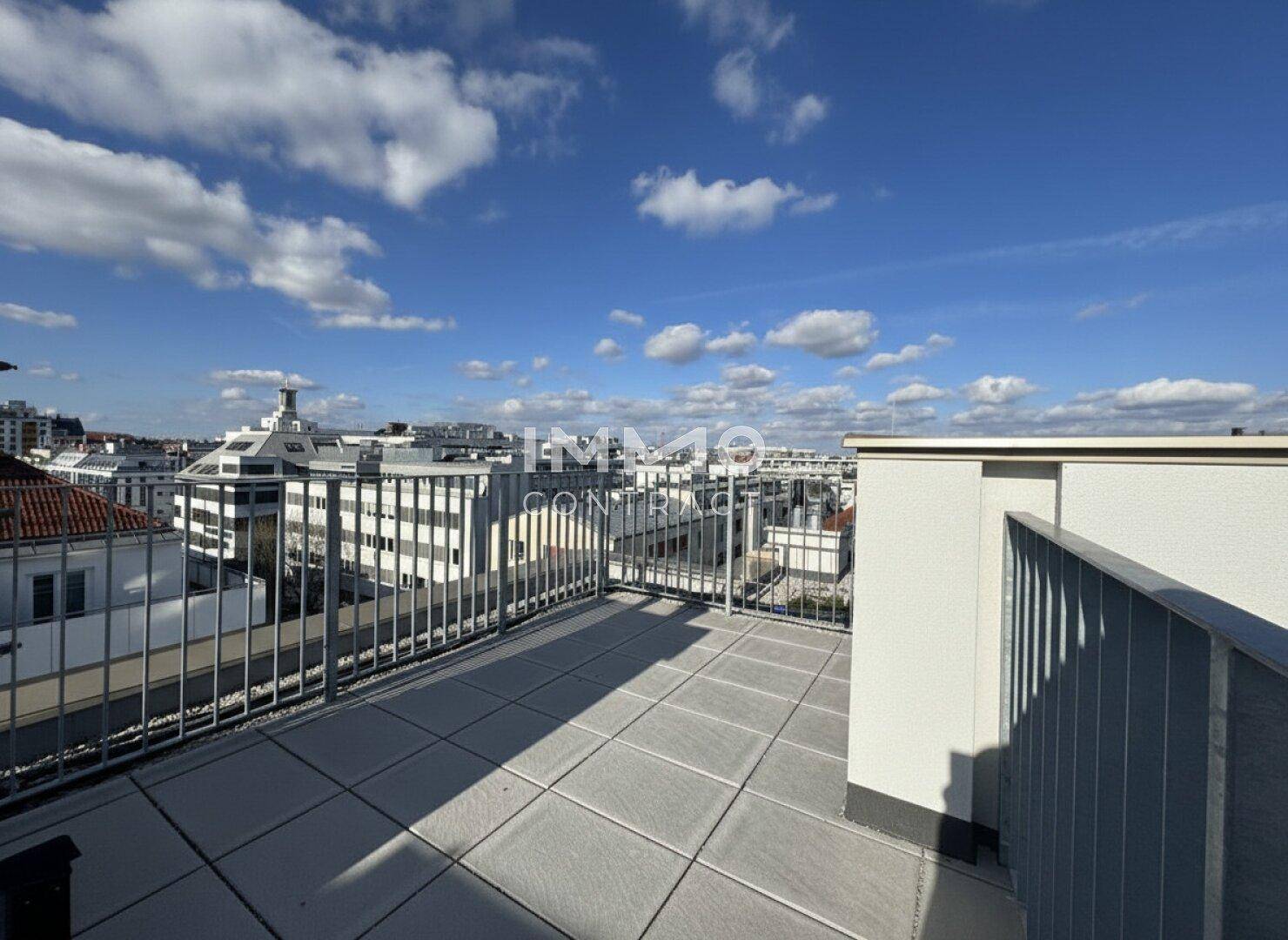 Offene Dachterrasse mit modernem Geländer und weitem Blick auf die umliegende Stadtlandschaft.