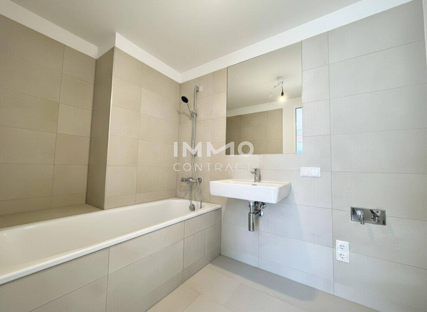Modernes Badezimmer mit integrierter Badewanne, Einzelwaschbecken und großem Spiegel.