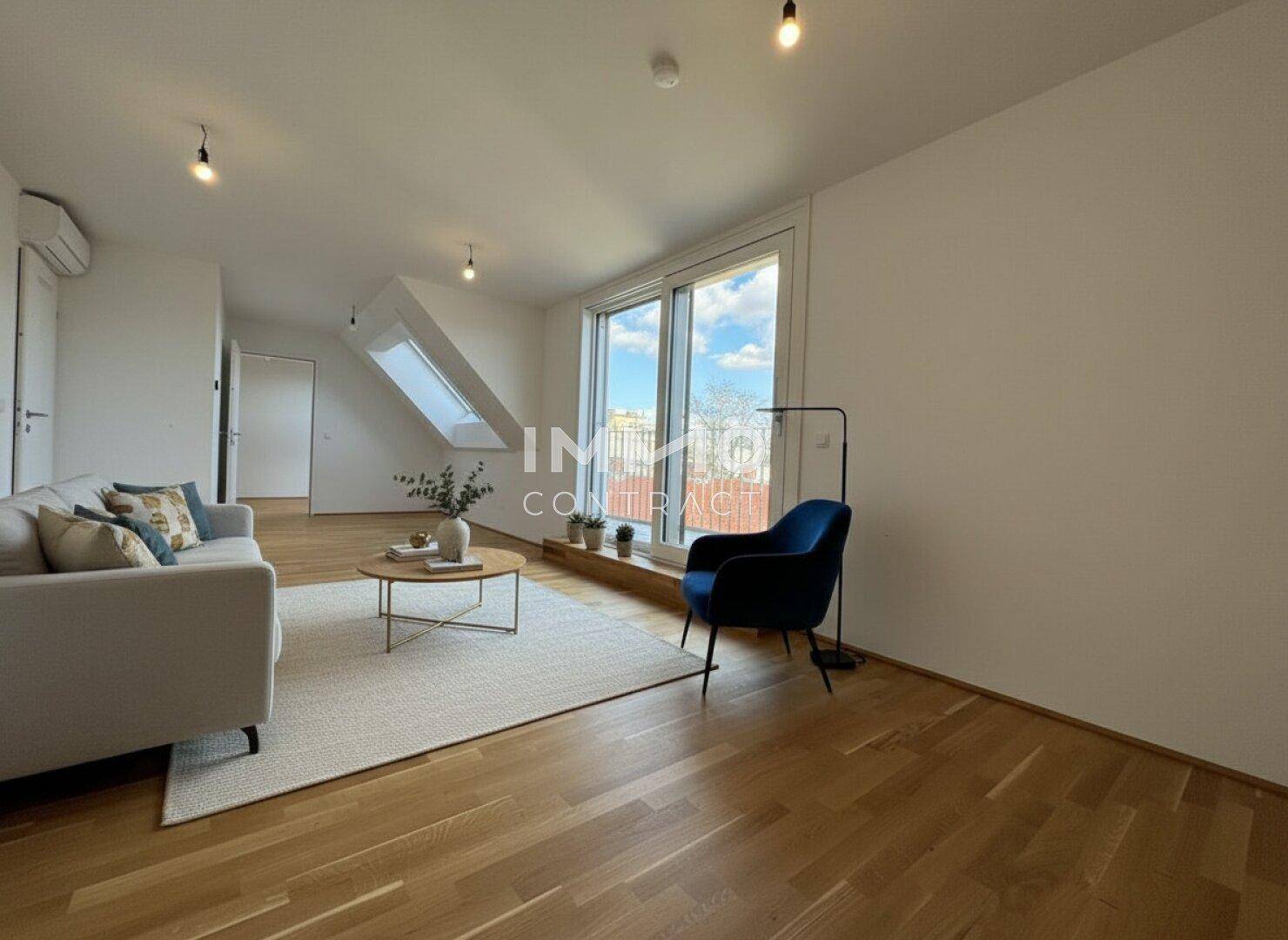Geräumiges Wohnzimmer mit Holzboden, Dachfenstern und Zugang zu einem Außenbereich.