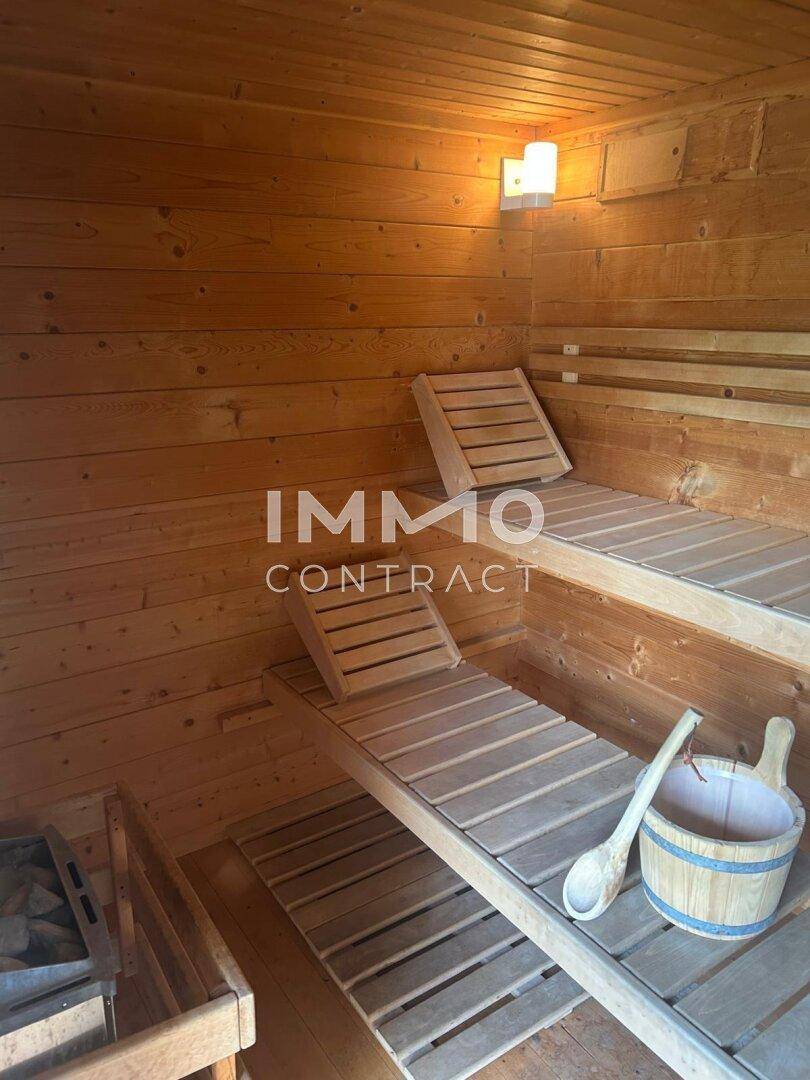 Traditionelle Holzsauna mit mehreren Bänken und Saunaofen für Entspannung.