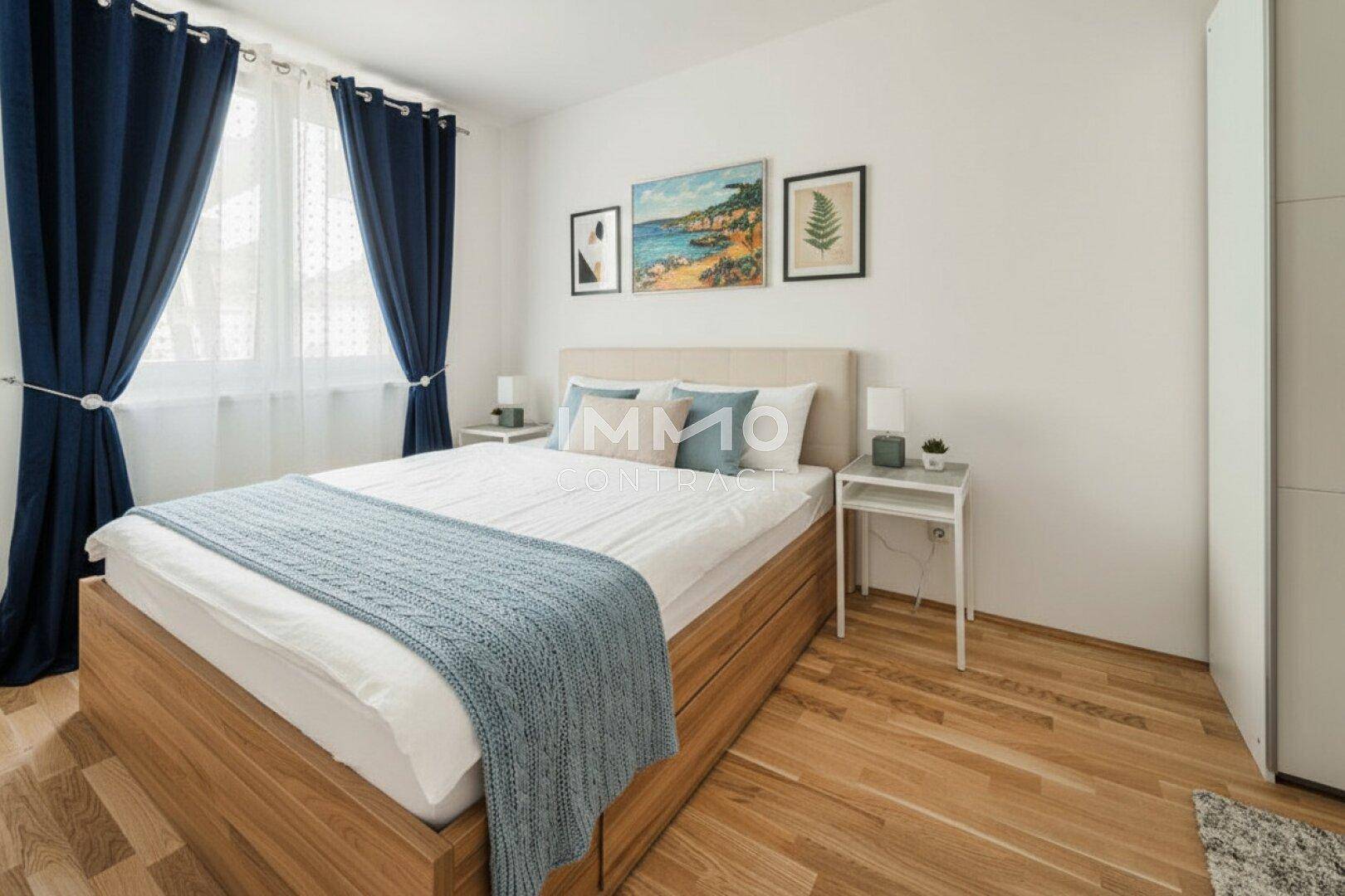 Gemütliches Schlafzimmer mit Holzbett, Parkettboden und blauen Vorhängen.
