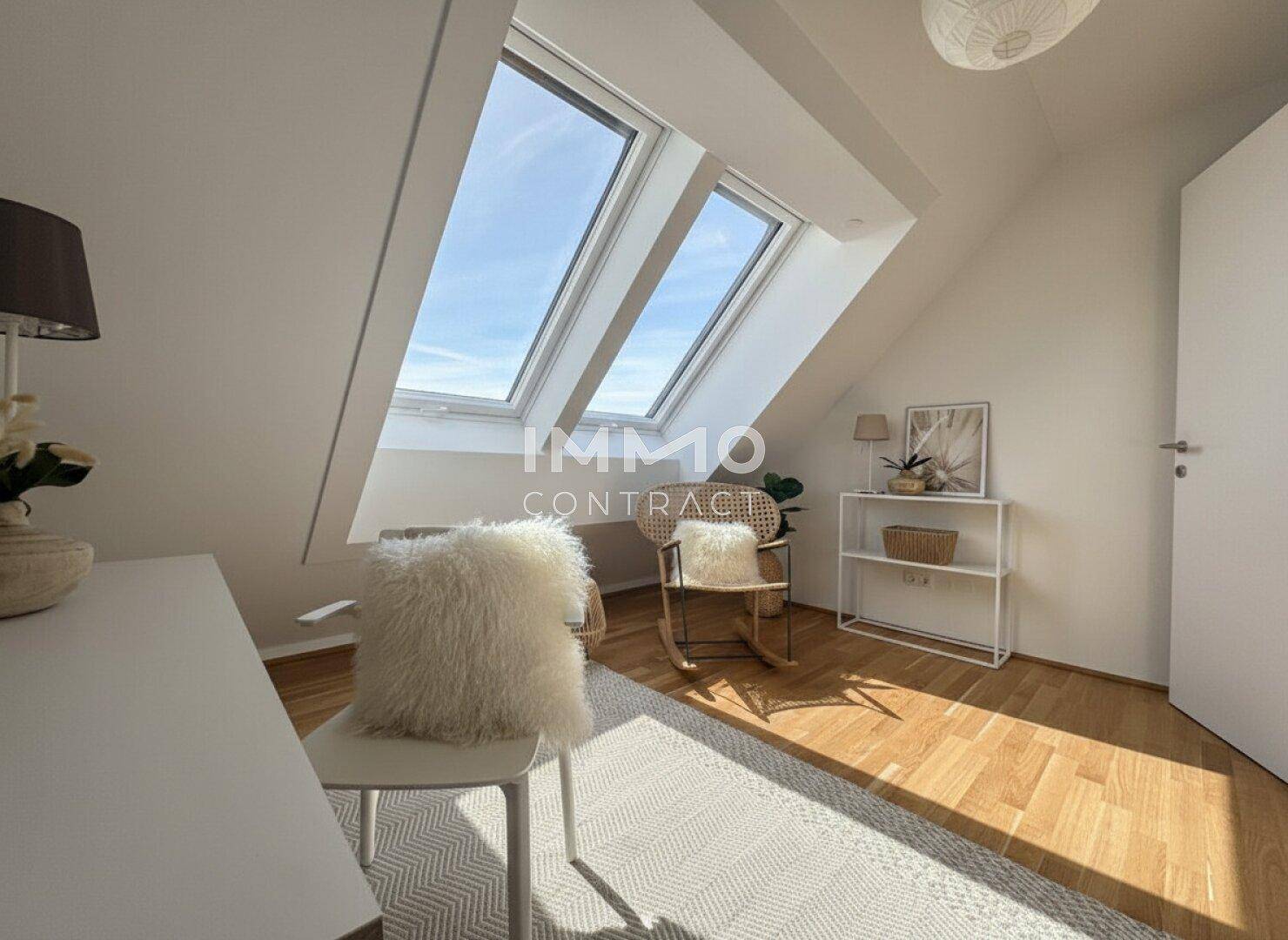 Gemütliches Zimmer im Dachgeschoss mit Schreibtisch, Holzboden und hellen Dachfenstern.