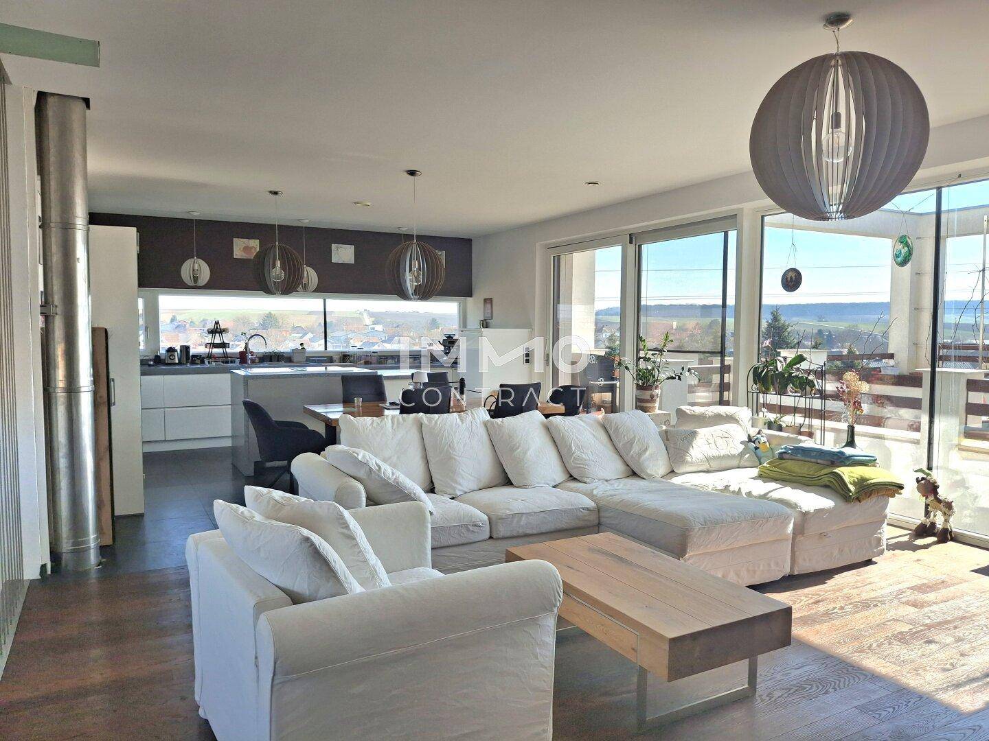 Geräumiger Wohnbereich mit bequemen Sofas, Holzboden und Zugang zur Terrasse.