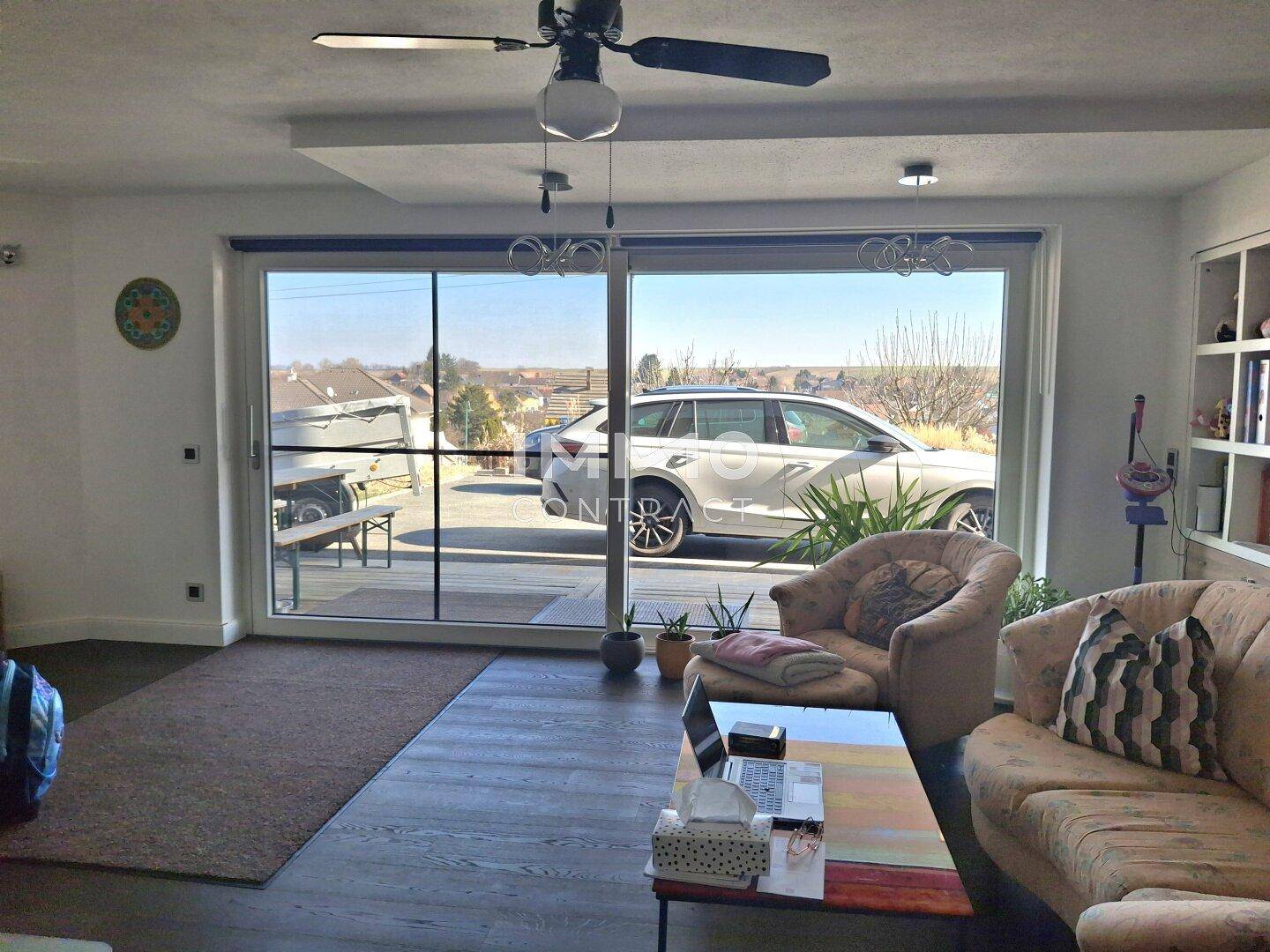 Helles Wohnzimmer mit großen Schiebetüren, die den Blick nach draußen freigeben.