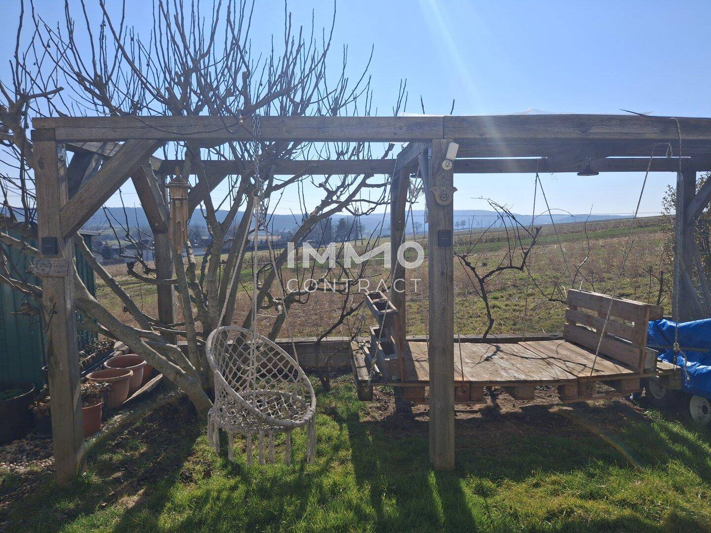 Gartenbereich mit Holzschaukel und viel Grün, ideal für Kinder.