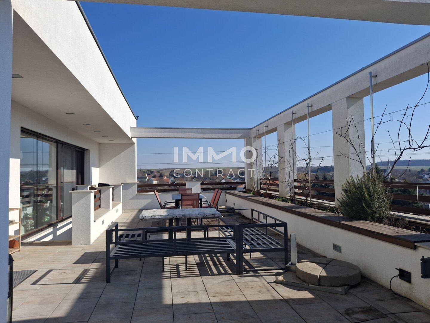 Große Dachterrasse mit Sitzgelegenheiten und weitem Panoramablick über die Umgebung.