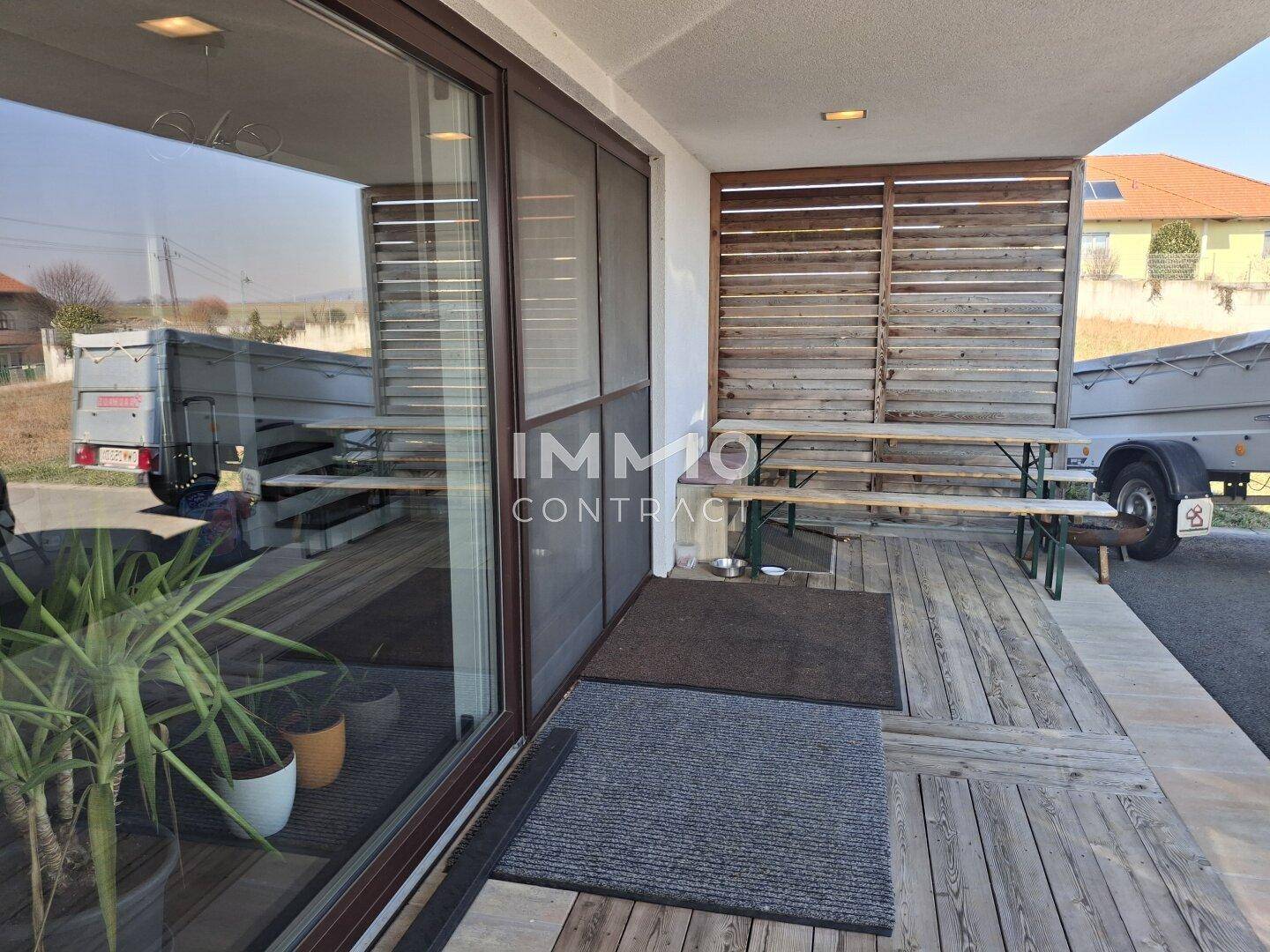 Überdachter Terrassenbereich mit Holzboden und Sichtschutz, ideal für Entspannung.