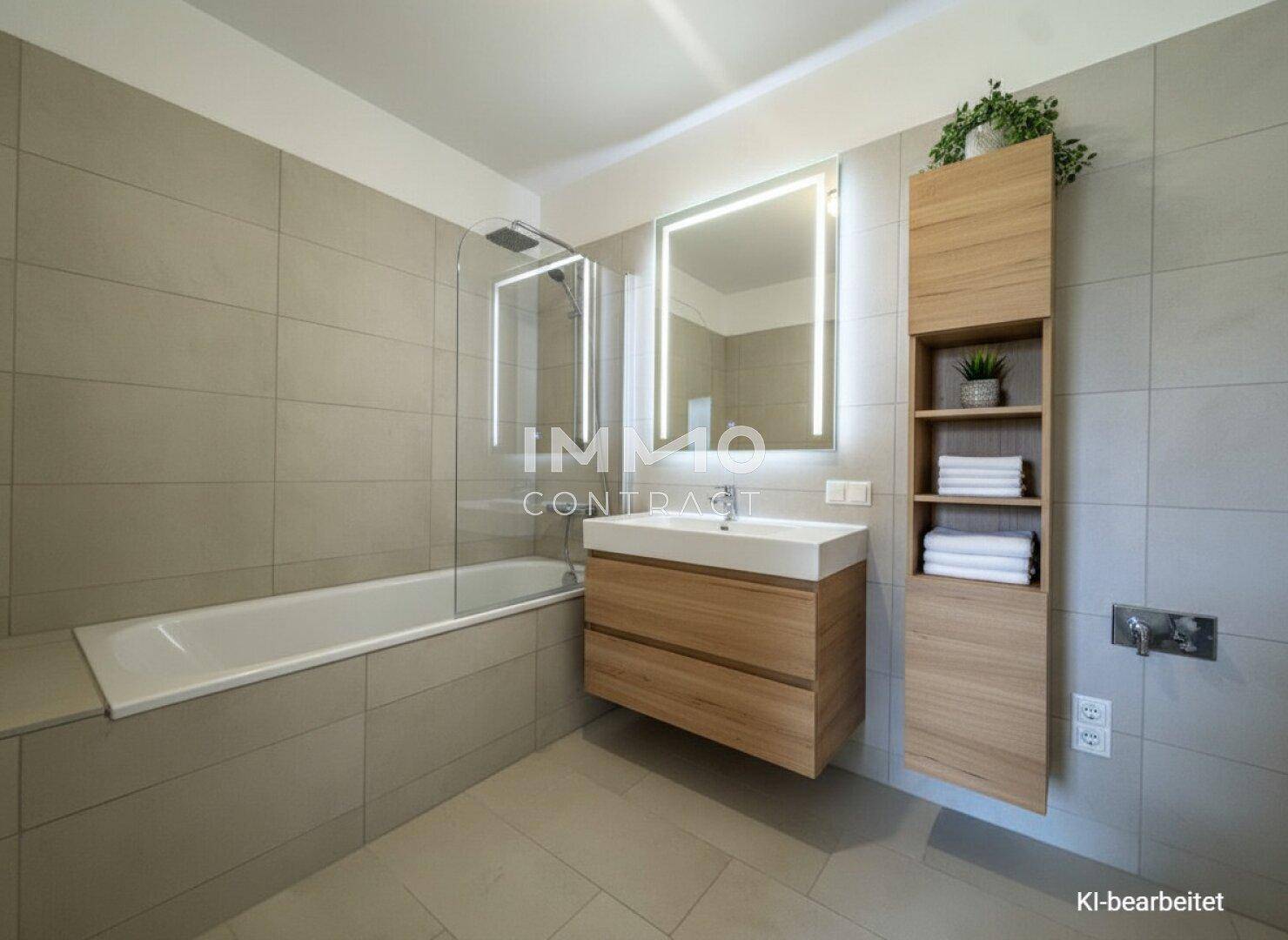 Modernes Badezimmer mit Badewanne, Dusche und beleuchtetem Spiegel.