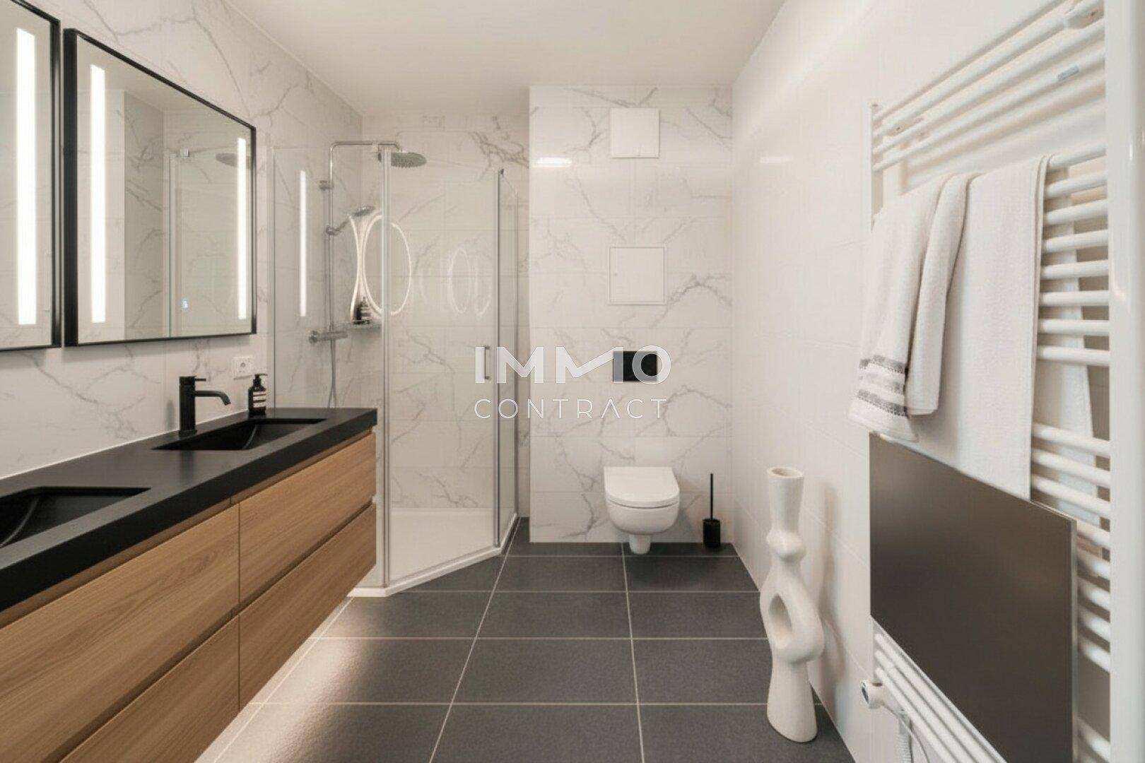 Modernes Badezimmer mit Doppelwaschbecken, begehbarer Dusche und eleganten Marmorfliesen.