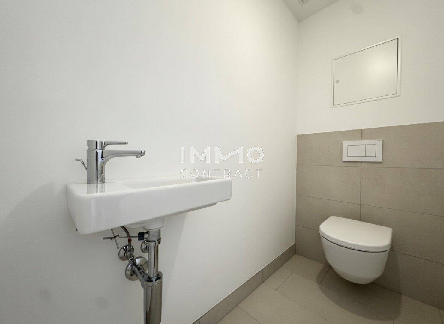 Kompaktes Gäste-WC mit wandhängender Toilette und modernem Einzelwaschbecken.