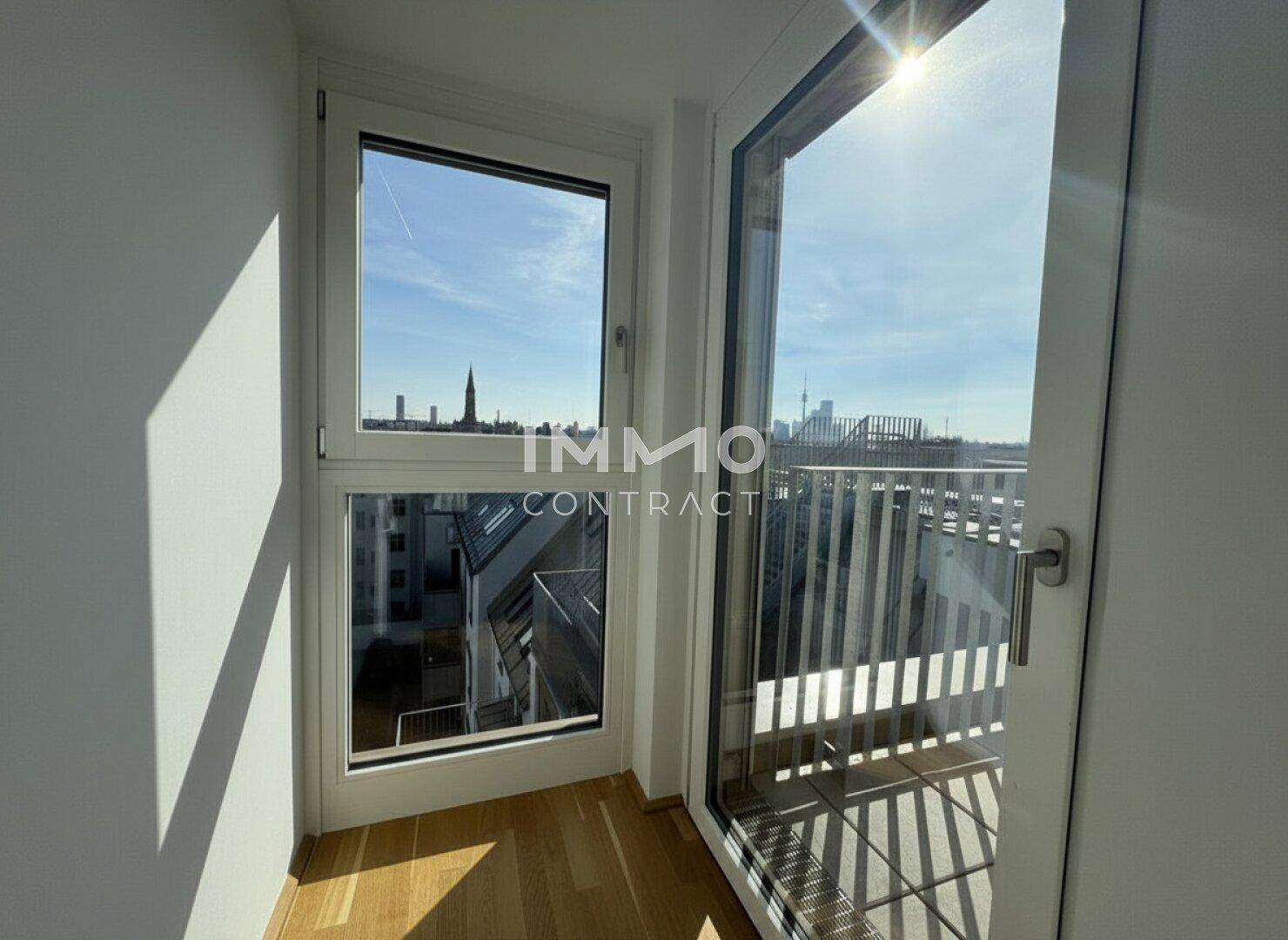 Heller Zugang zu einem Außenbereich mit Blick auf die Stadt und umliegende Gebäude.
