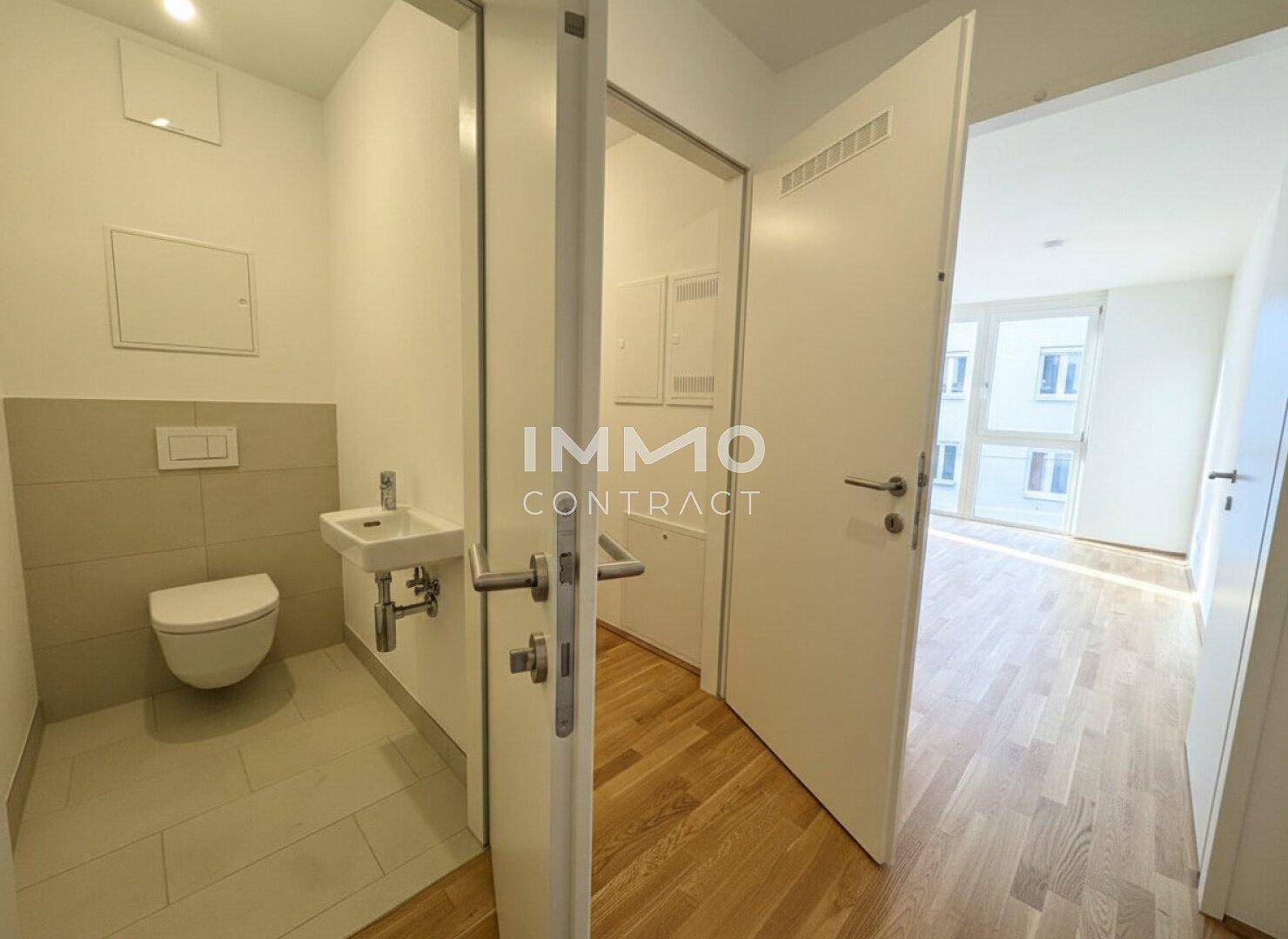 Separates Gäste-WC mit wandhängender Toilette und kleinem Waschbecken.