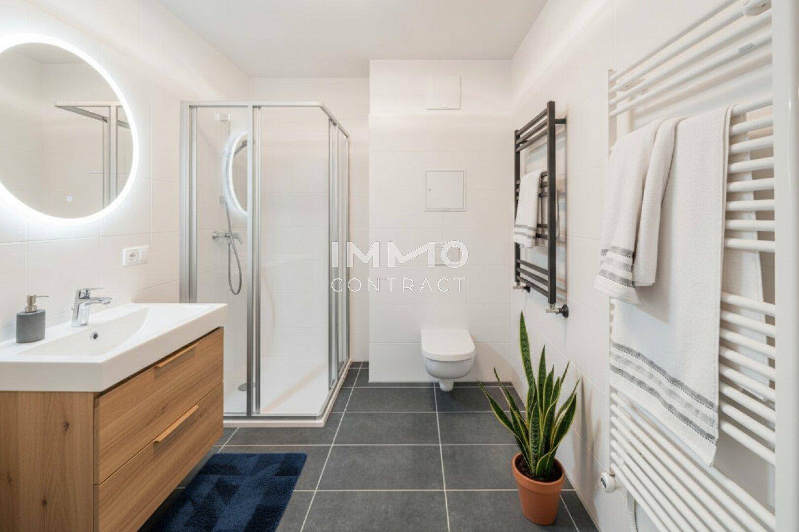 Modernes Badezimmer mit Dusche, Holzwaschtisch und beheiztem Handtuchhalter.