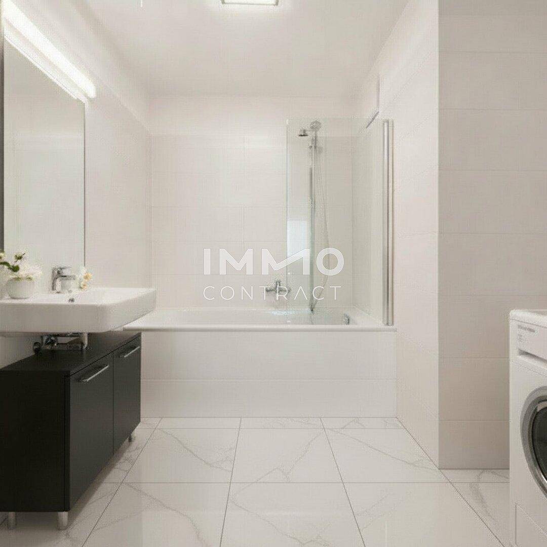 Helles Badezimmer mit Badewanne, Duschabtrennung und modernen weißen Fliesen.