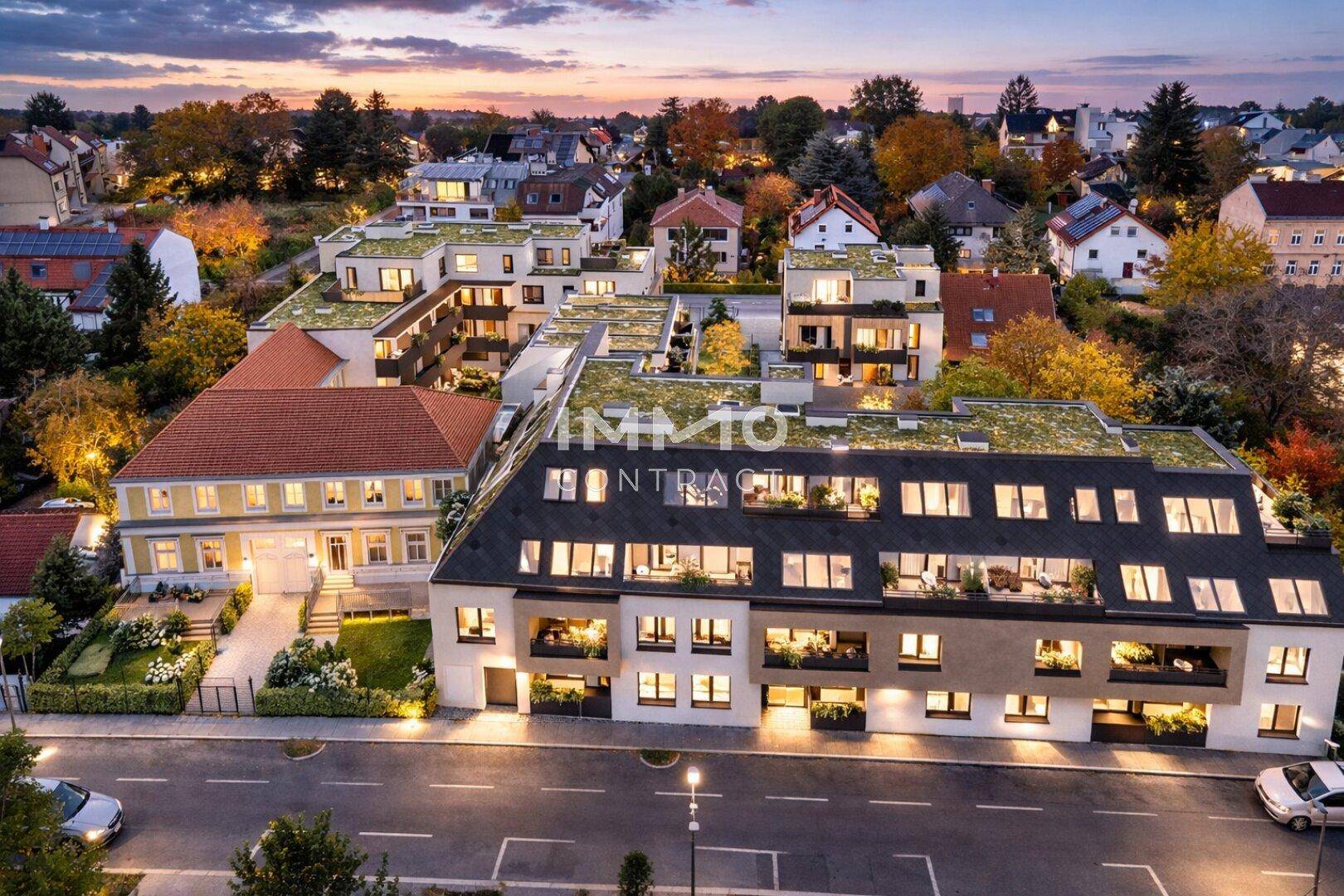 Luftaufnahme des Wohnkomplexes bei Sonnenuntergang, umgeben von einer ruhigen Wohngegend mit viel Grün.