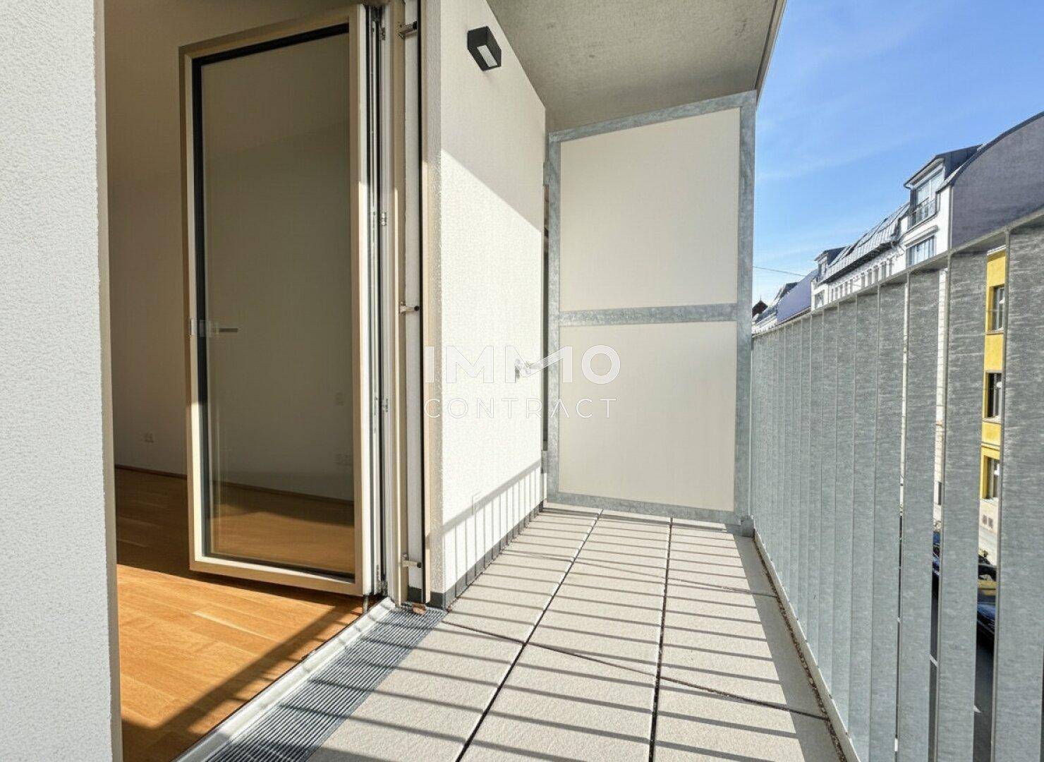 Schmaler Balkon mit Fliesenboden und Blick auf die Straße.