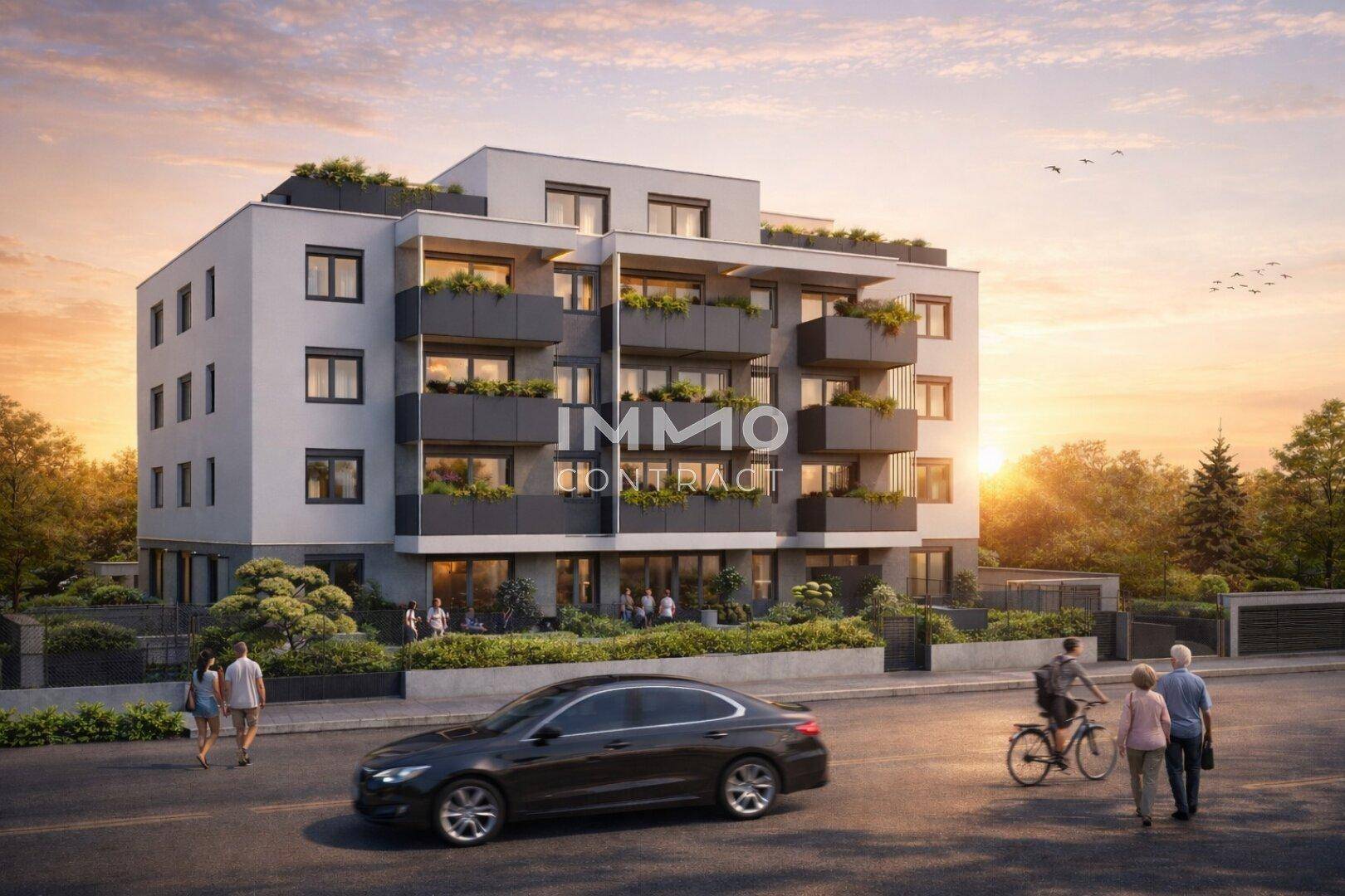 Modernes Mehrfamilienhaus mit Balkonen und begrünten Fassaden in einer ruhigen Wohngegend bei Sonnenuntergang.