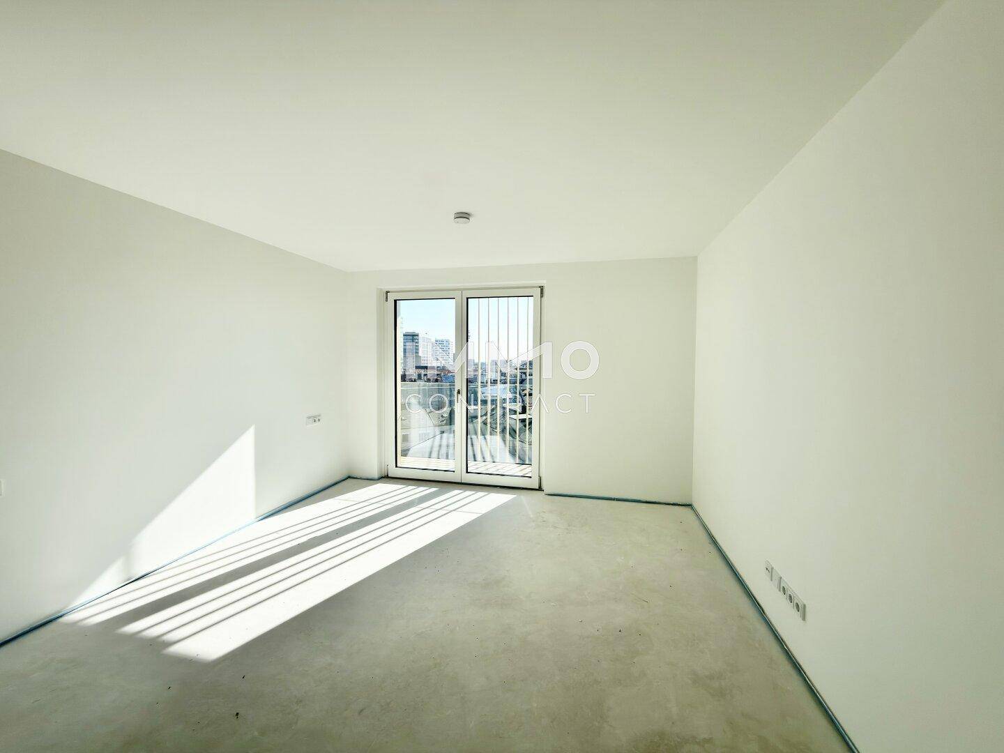 Helles, unmöbliertes Zimmer mit großen Fenstern und Zugang zu einem französischen Balkon, bereit zur individuellen Gestaltung.