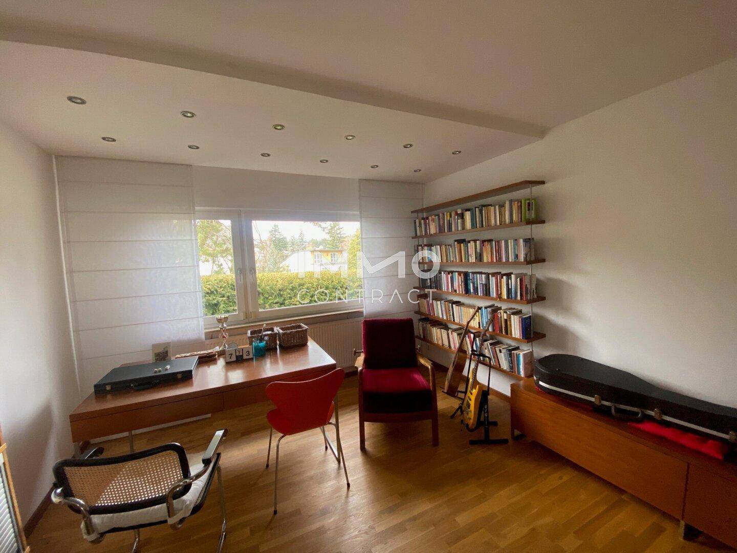 Geräumiges Arbeitszimmer mit Schreibtisch, Bücherregal und viel Tageslicht.