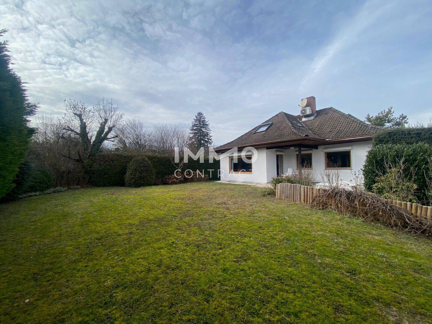 Großer Garten mit weitläufiger Rasenfläche und Blick auf die Rückseite des Hauses.