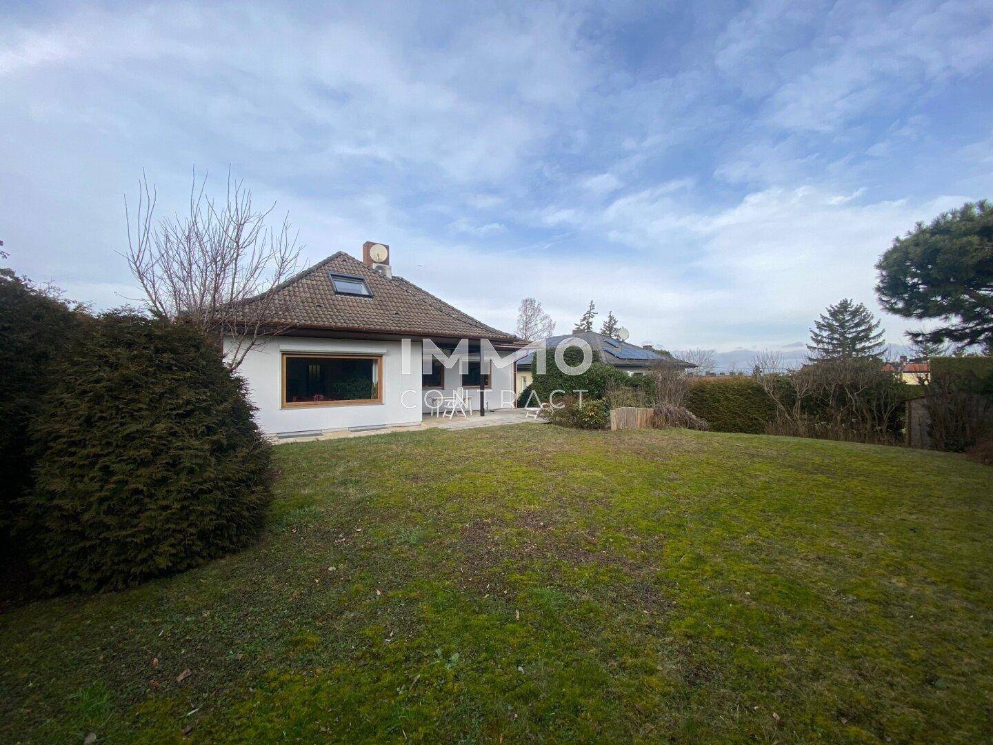 Weitläufiger Garten mit großer Rasenfläche und Blick auf das Haus im Hintergrund.