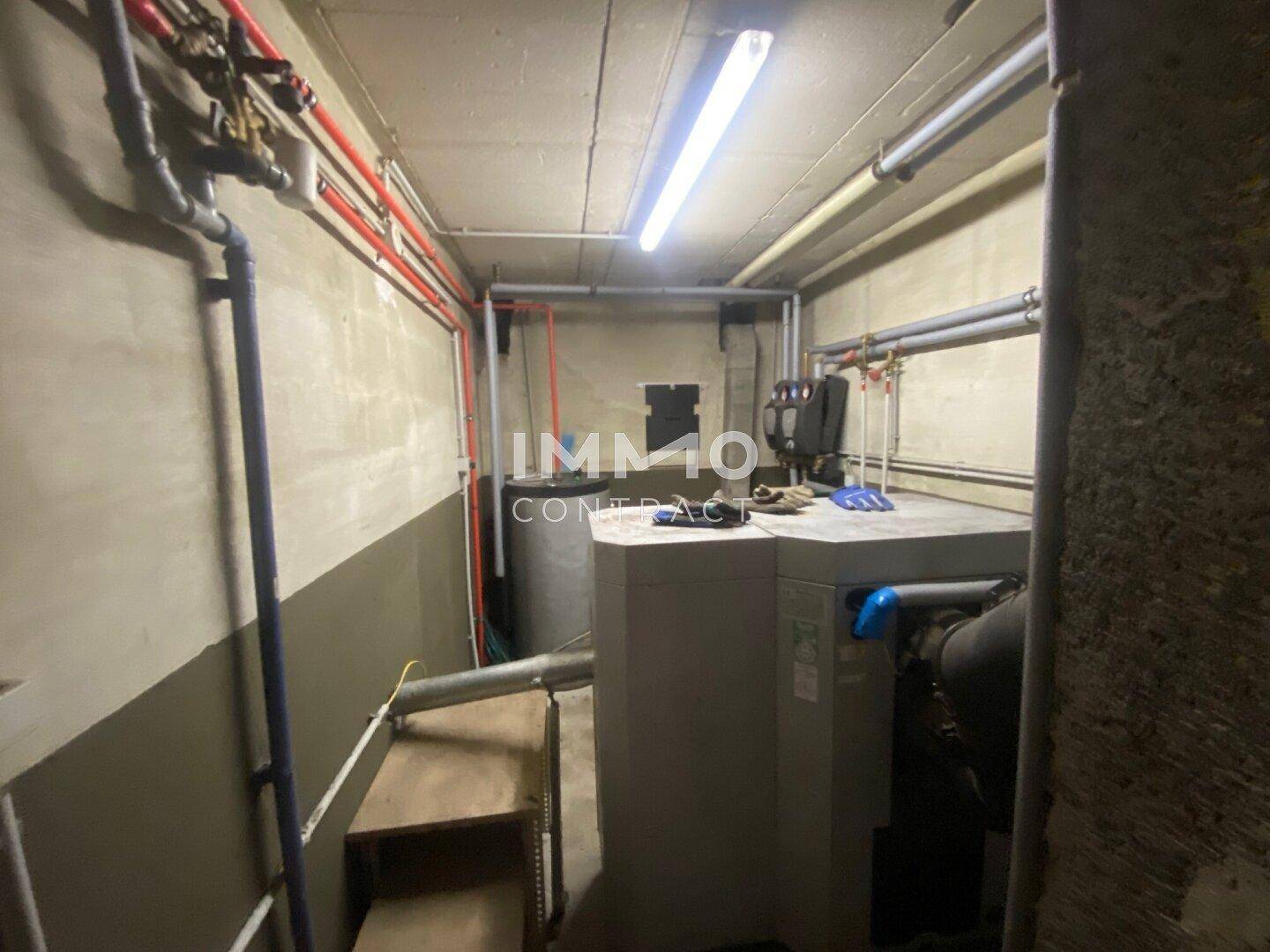 Heizungsraum im Keller mit moderner Heizungsanlage und sichtbaren Rohrleitungen.