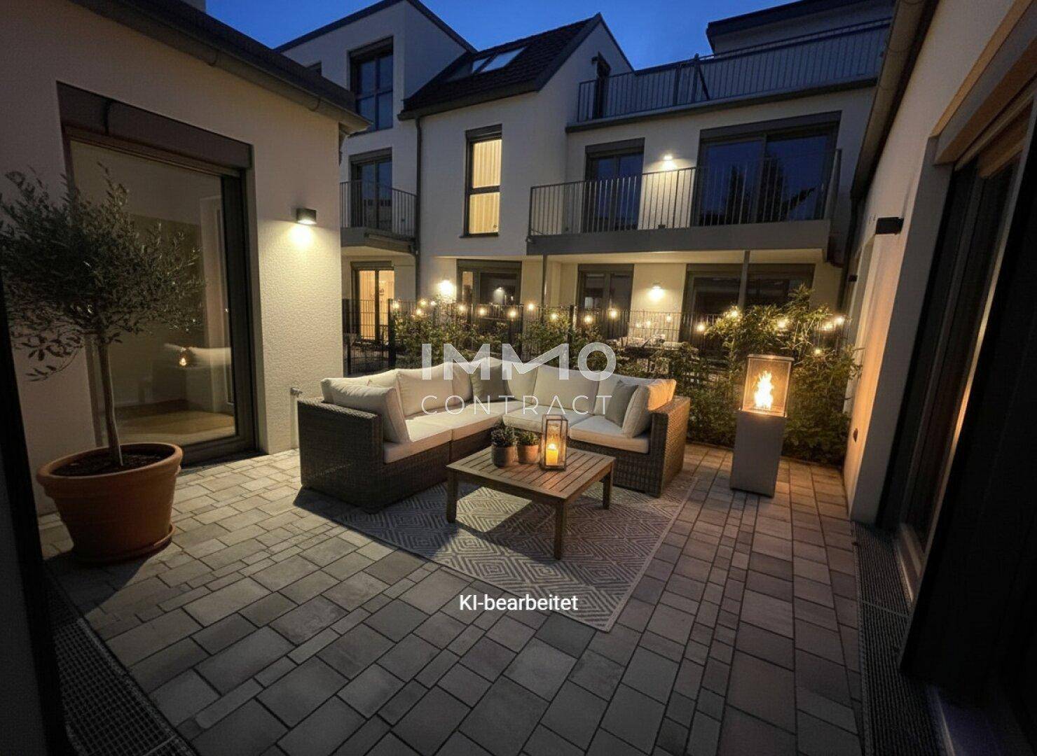 Stimmungsvolle Terrasse am Abend mit Outdoor-Möbeln, Lichterkette und dekorativer Feuerstelle.