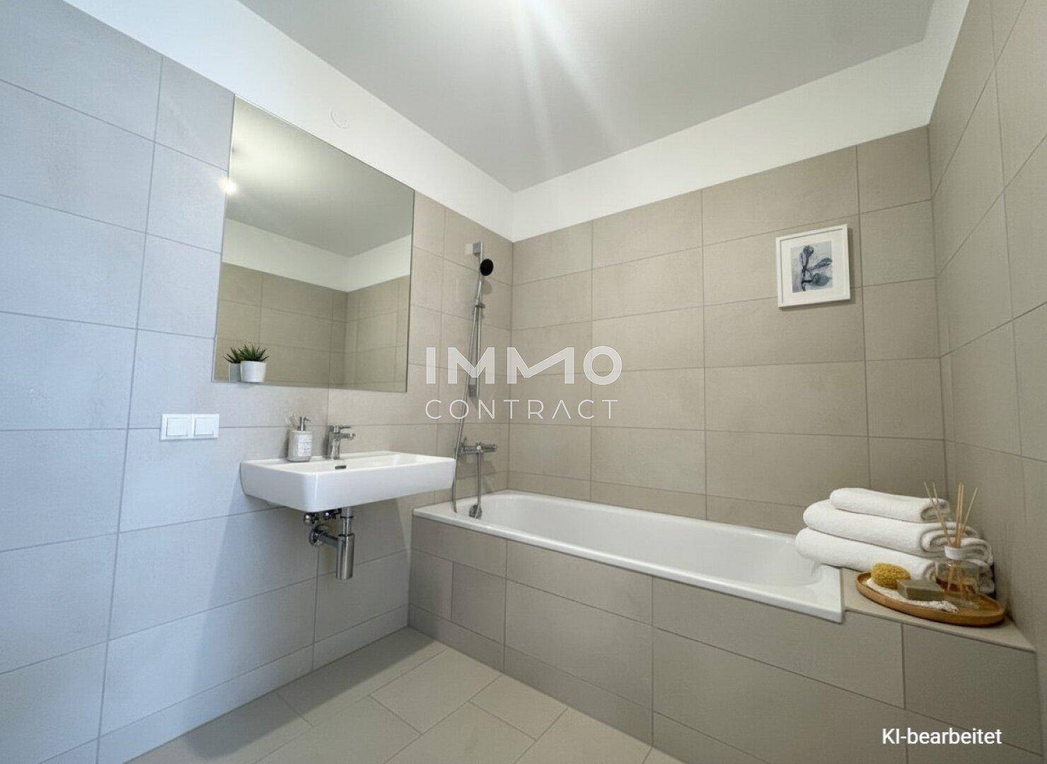 Modernes Badezimmer mit beigefarbenen Fliesen, Badewanne und Einzelwaschbecken.