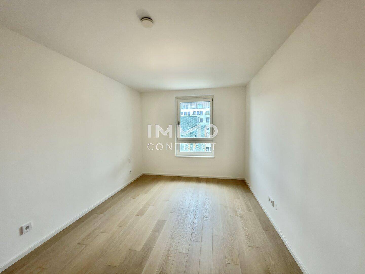 Leeres Zimmer mit hellem Parkettboden und einem Fenster, bereit zur individuellen Gestaltung.