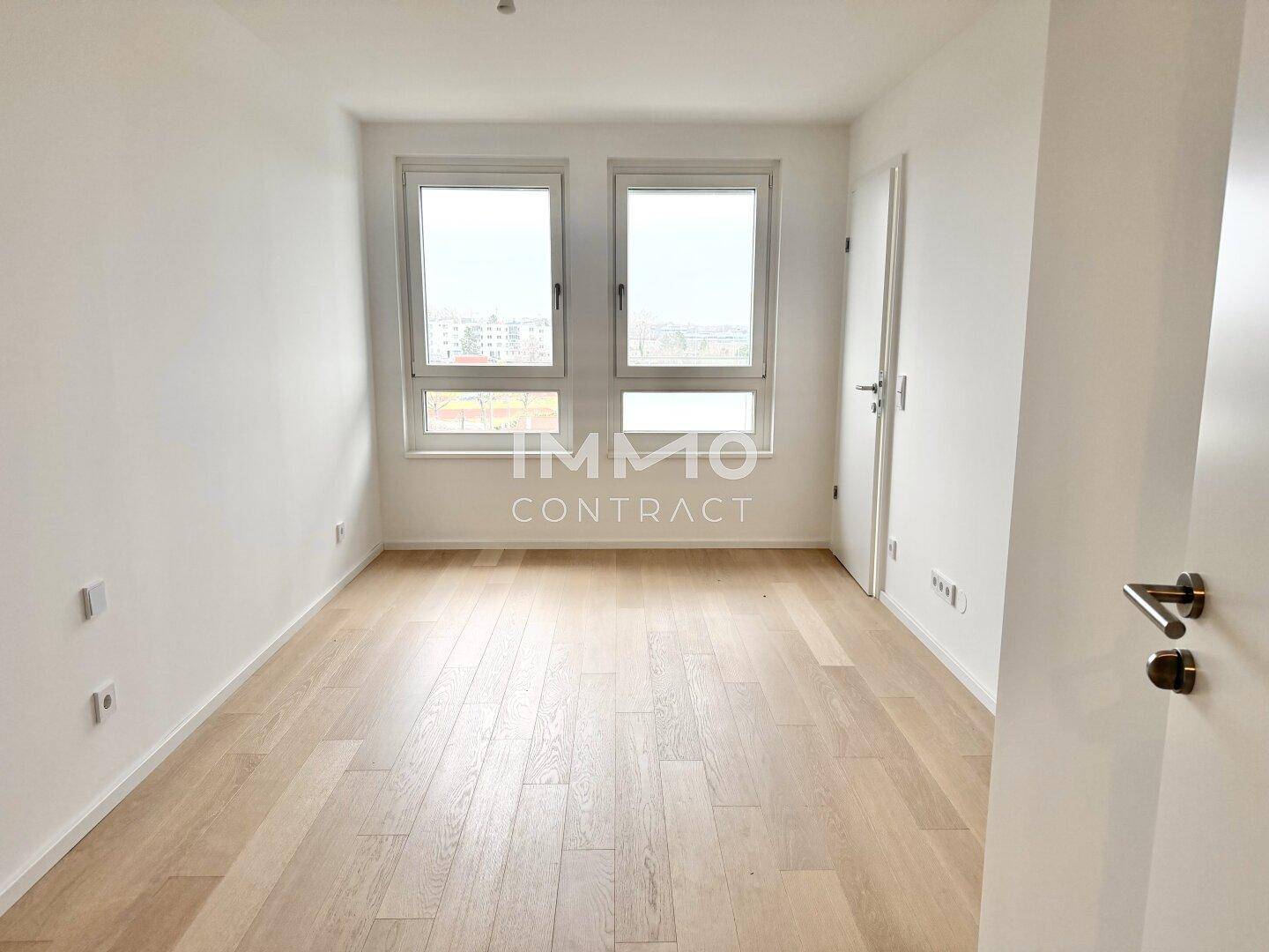 Helles Zimmer mit zwei Fenstern und Parkettboden, ideal als Schlaf- oder Arbeitszimmer.