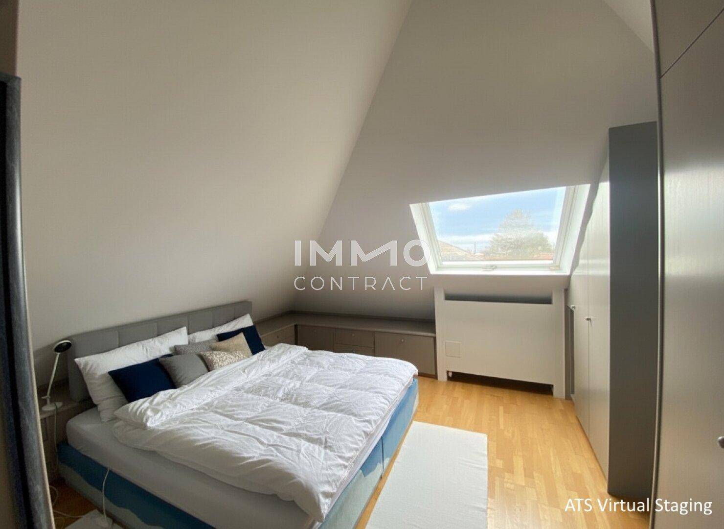 Schlafzimmer im Dachgeschoss mit schrägen Wänden, Dachfenster und Holzboden.