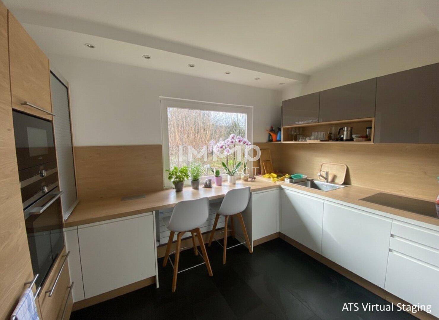 Moderne Küche mit Holzarbeitsplatten, weißen Unterschränken und integriertem Essbereich am Fenster.