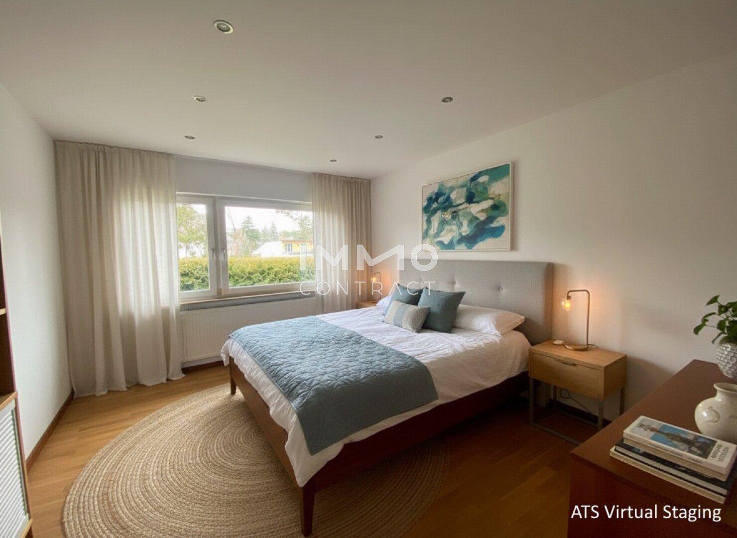 Helles Schlafzimmer mit Doppelbett, Holzboden und großen Fenstern mit Blick ins Grüne.