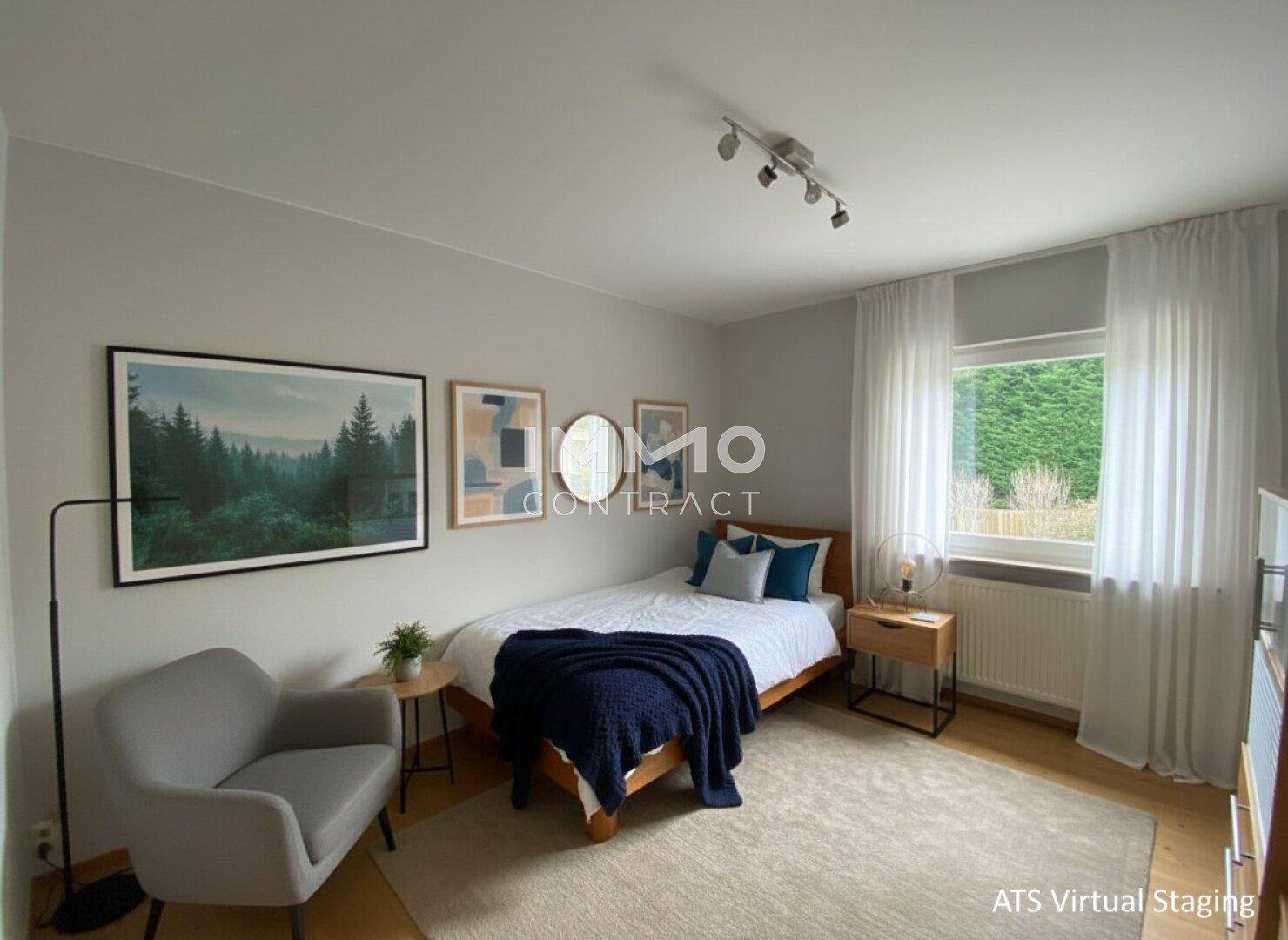 Helles Schlafzimmer mit Einzelbett, Holzboden und Blick ins Grüne durch das Fenster.