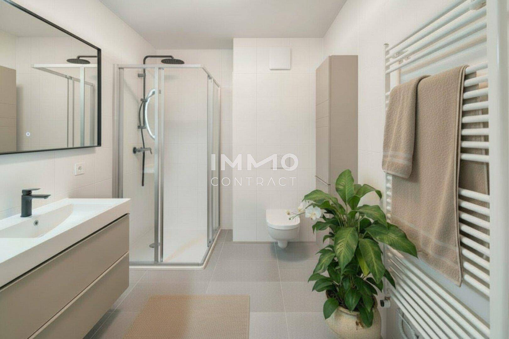 Modernes Badezimmer mit ebenerdiger Dusche, Einzelwaschbecken und Handtuchheizkörper.
