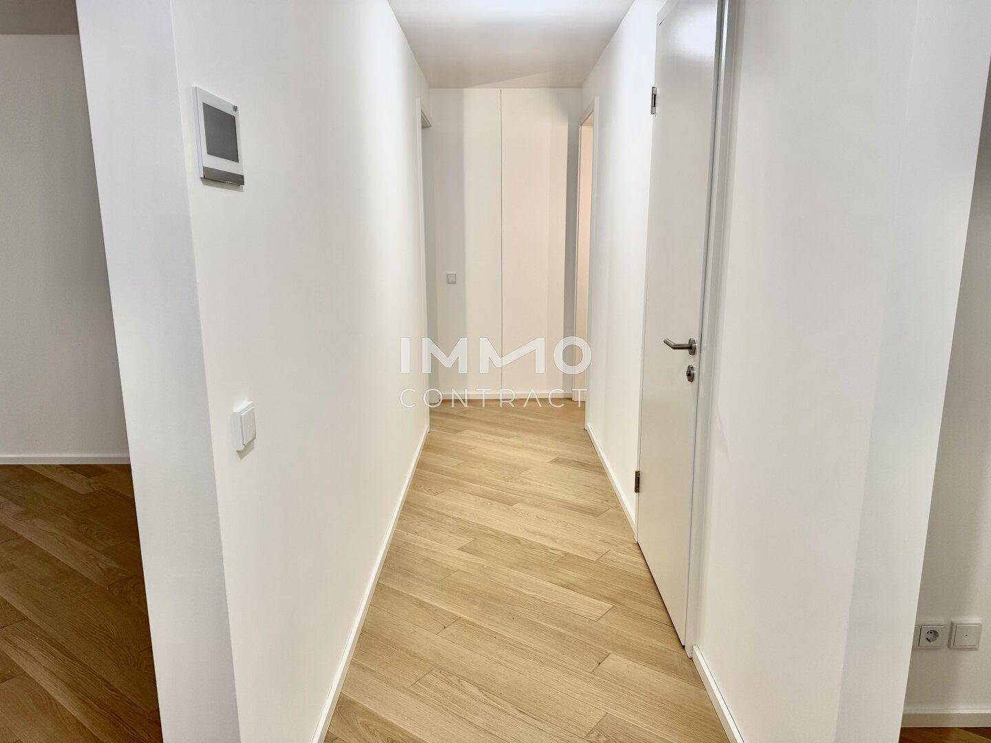 Heller Flur mit Parkettboden, der zu den verschiedenen Räumen der Wohnung führt.