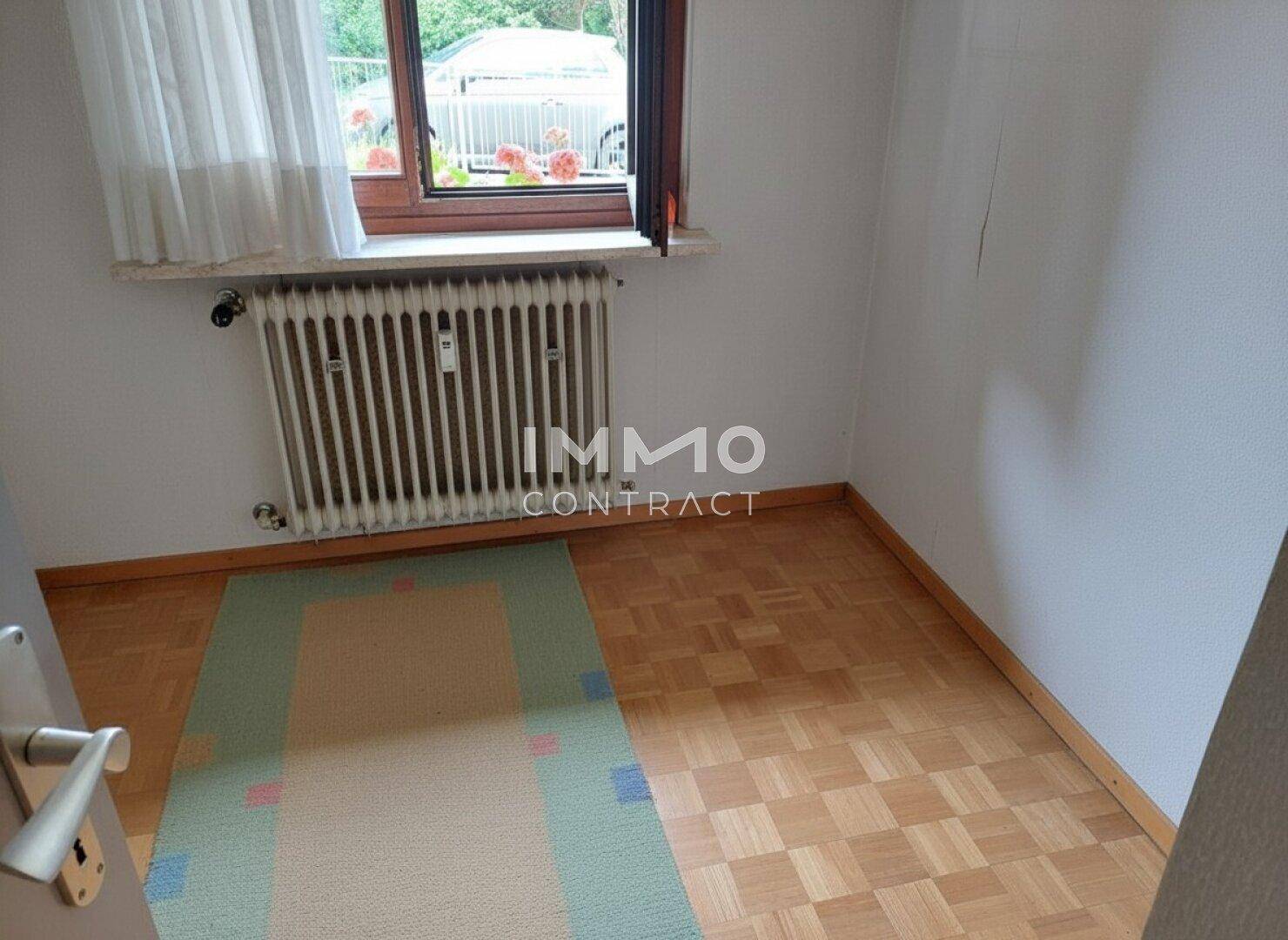 Kleines Schlafzimmer mit Parkettboden und Fenster, ideal als Kinder- oder Gästezimmer.
