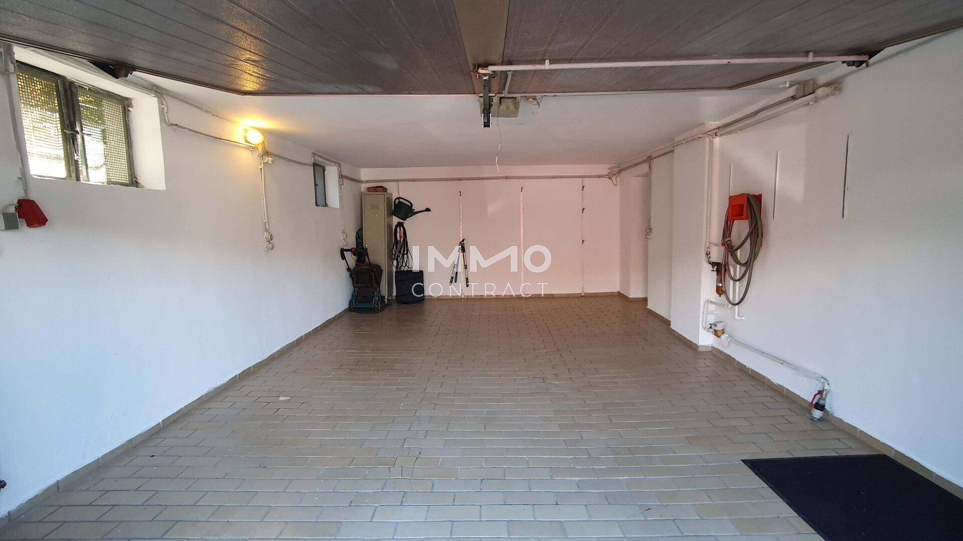 Geräumige Garage mit Fliesenboden und ausreichend Platz für Fahrzeuge und Lagerung.