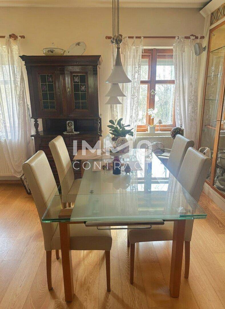 Klassischer Essbereich mit einem Glastisch, bequemen Stühlen und einem antiken Holzschrank, ideal für Mahlzeiten.