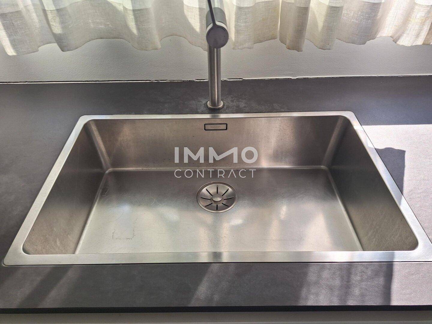Edelstahlspüle mit modernem Wasserhahn in der minimalistischen Küche.