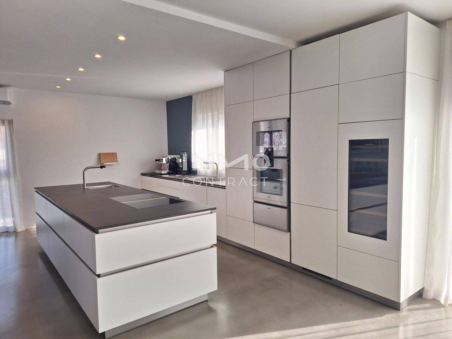Elegante Küche mit minimalistischem Design, integriertem Weinkühler und hochwertigen Geräten.