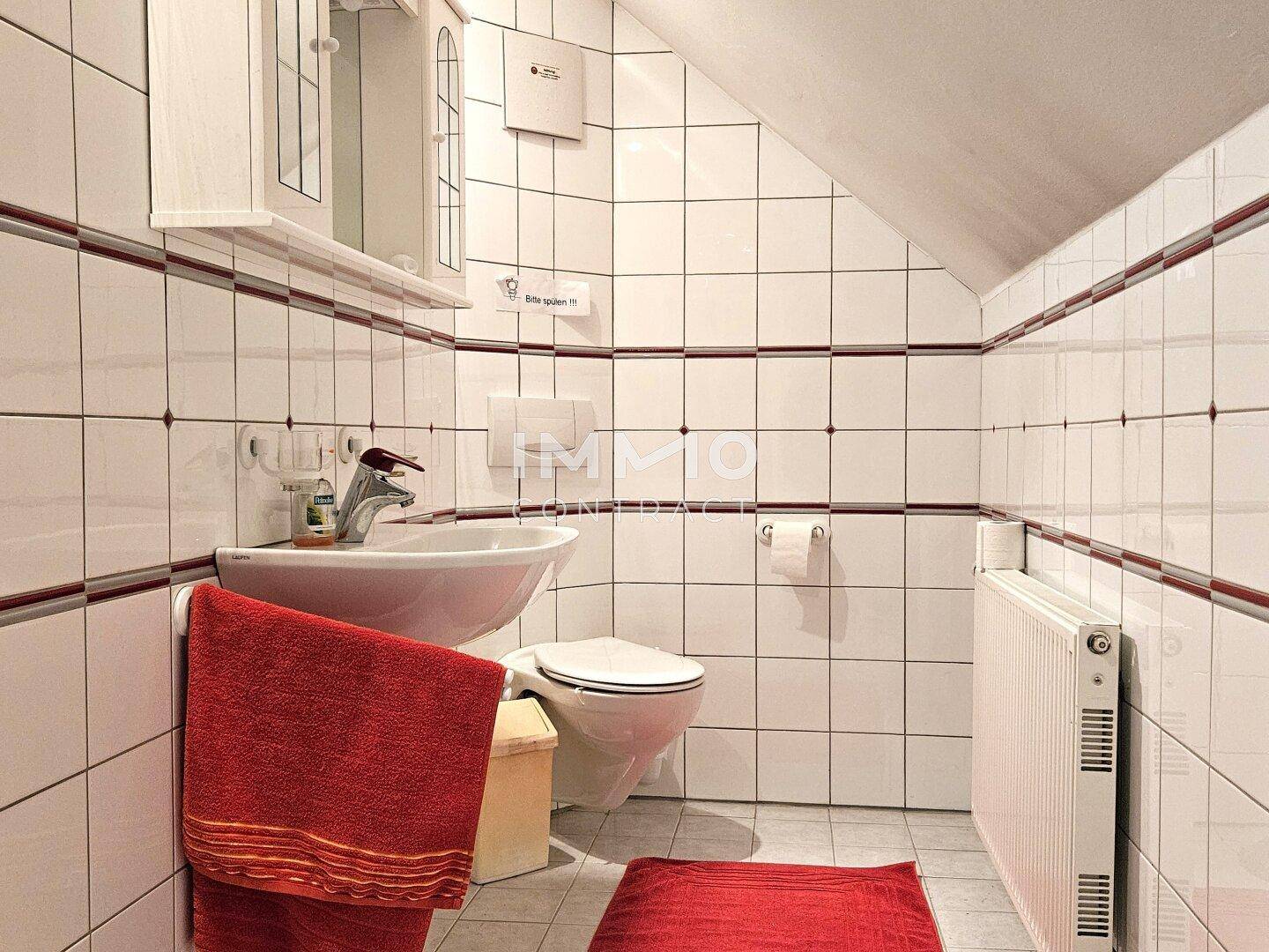 Kleines Badezimmer im Dachgeschoss mit WC, Waschbecken und Dusche.