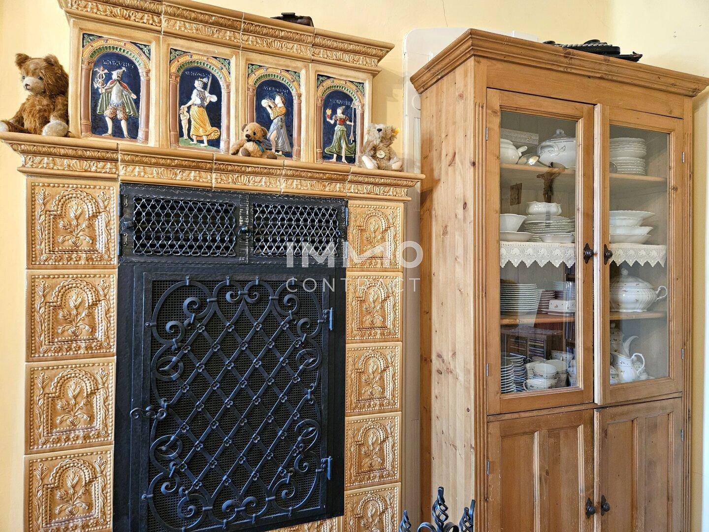 Detailansicht eines kunstvoll verzierten Kachelofens mit traditionellen Motiven.