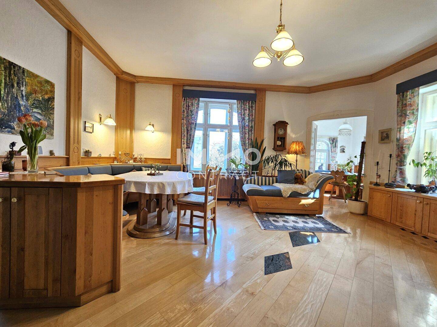 Offener Wohnbereich mit Holzelementen, Sitzbank und Blick in den Garten.