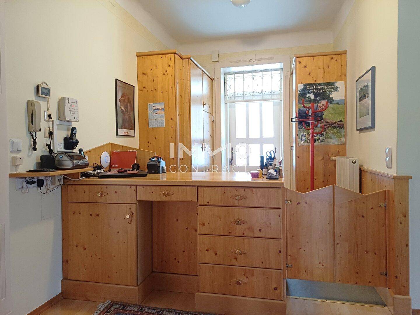 Funktionales Büro mit Holzmöbeln, Schreibtisch und Fenster.