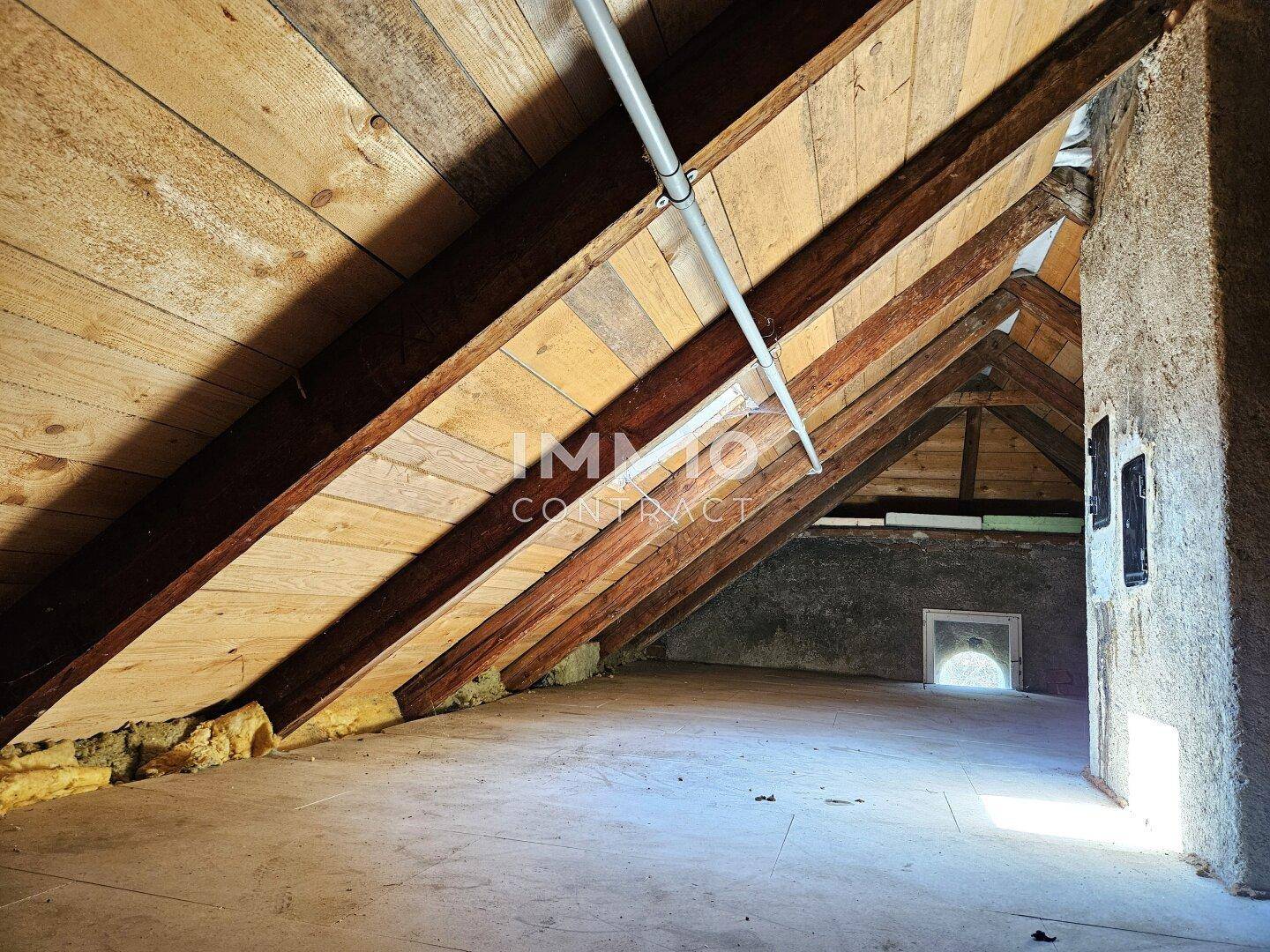 Unausgebauter Dachboden mit sichtbaren Holzbalken und viel Stauraum.