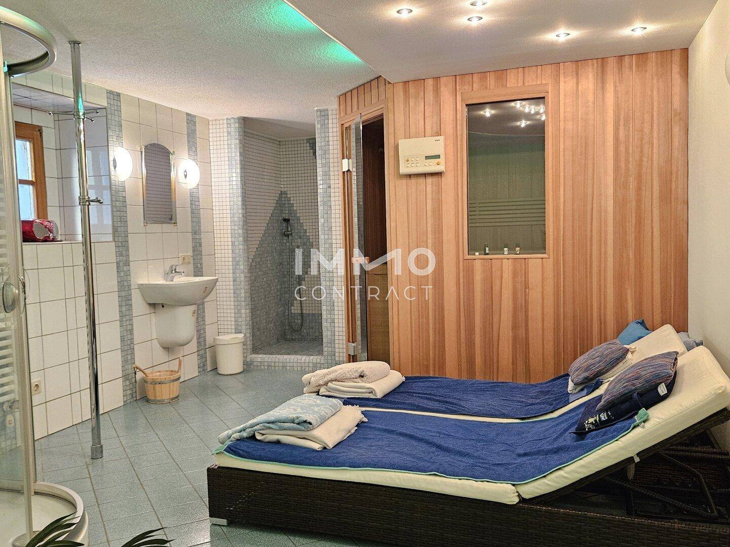 Moderner Wellnessbereich mit Sauna, Dusche und Liegeflächen zur Entspannung.