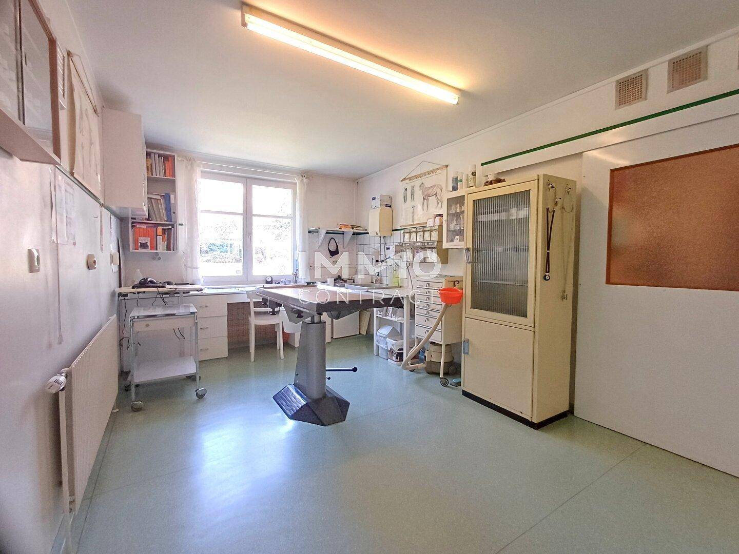 Funktionaler Raum mit großem Fenster, Arbeitstisch und medizinischen Geräten.